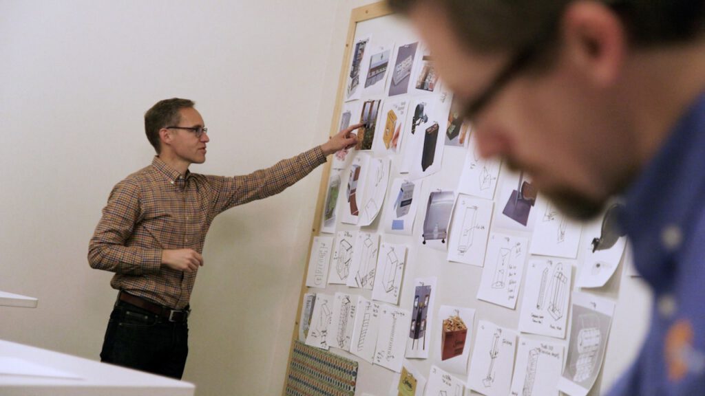 Industrial Designers work at the early stages of product design in front of a giant whiteboard.