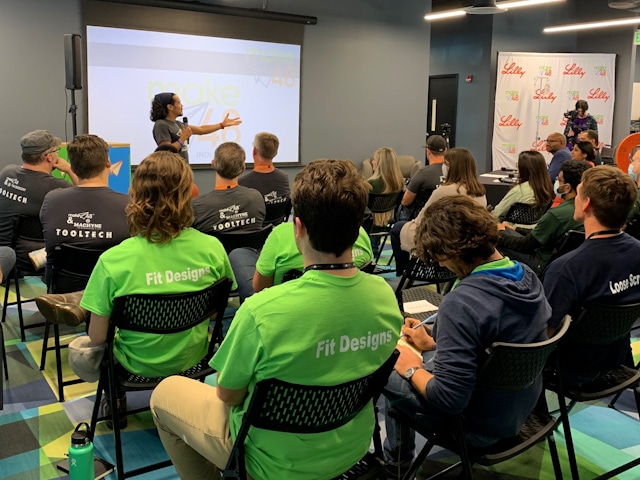 A group of contestants listen to a speaker at the Make48 competition.
