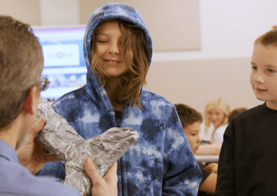 This kid in a blue hoodie looks very pleased with what Andrew has to say about a dolphin tail prosthesis.