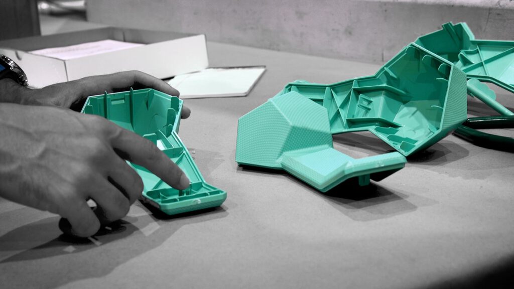 A client inspects one of the first plastic injection components in a run of new medical devices.