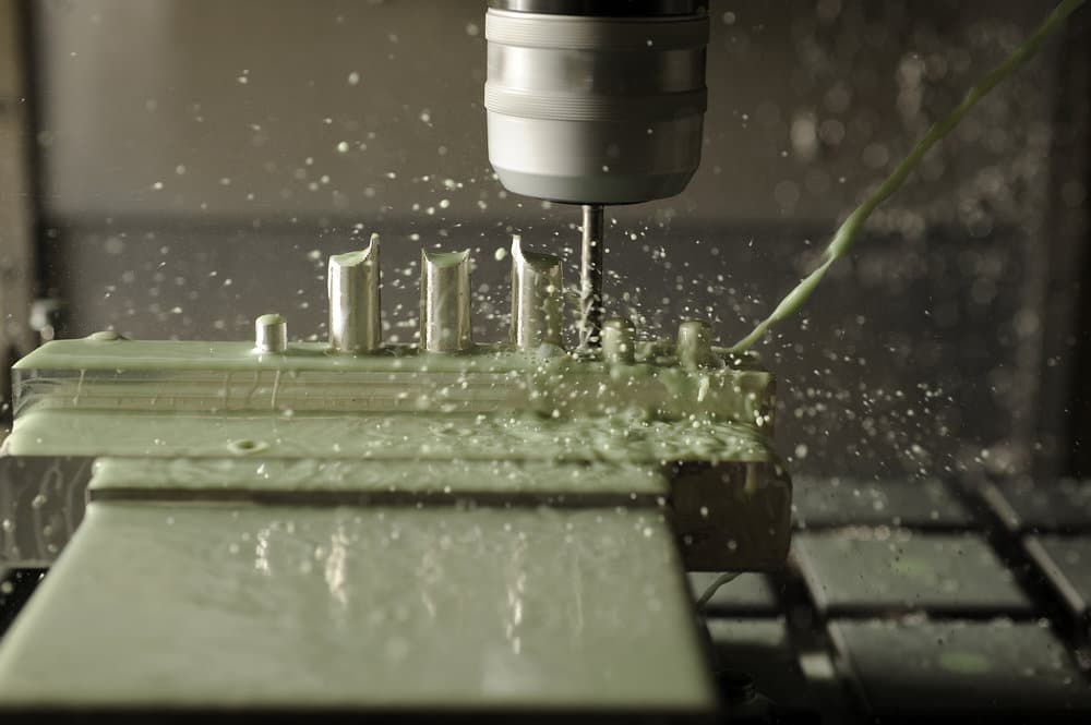 Contact between a CNC mill end and a block of aluminum.