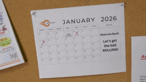 The Holiday Hangover is here. A breakroom calendar is displayed noting that it is January 2026. A note welcomes employees back to work after the holidays. It encourages everyone to get the ball rolling.